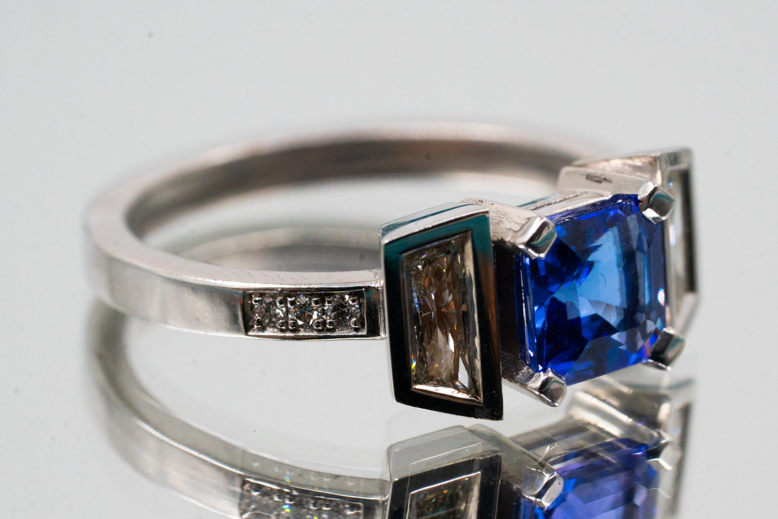 Bague pierre bleu-violet taille carrée entre deux diamants trapèze