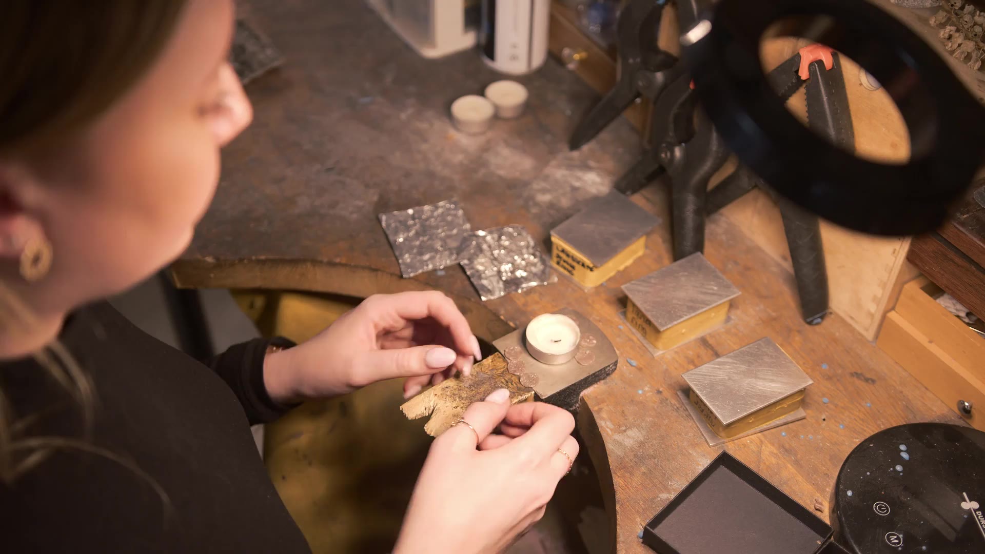 Joaillière à l'établi, plaques de métal et outils de l'atelier de Spa
